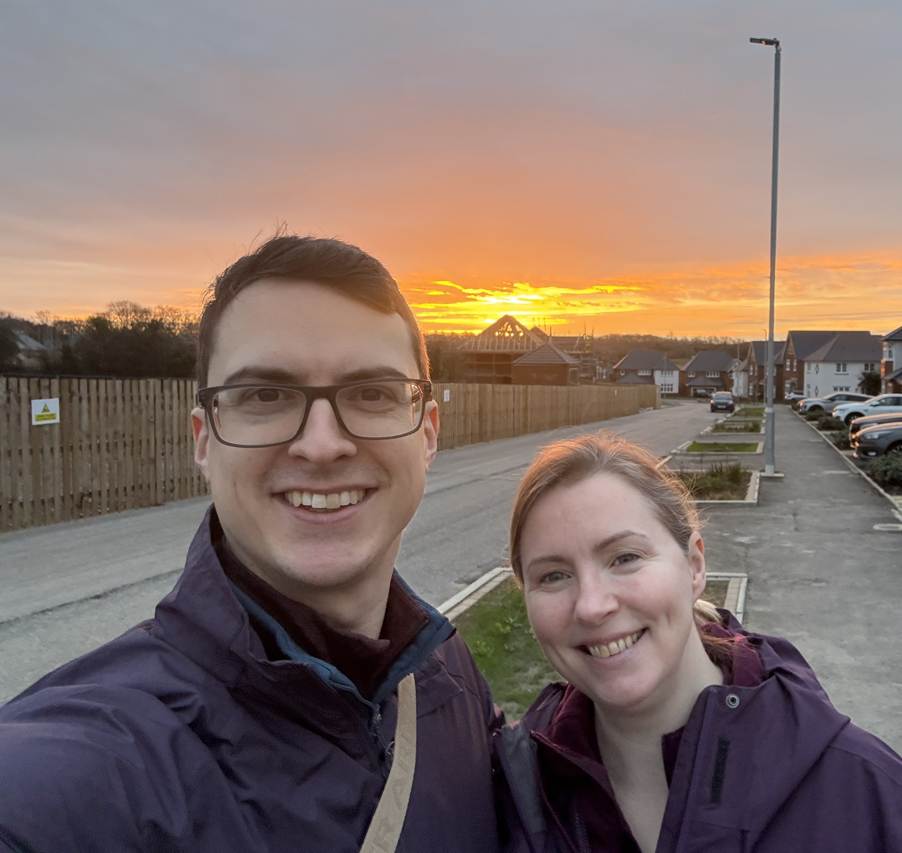 Jon and Lucy, founders of Caru Pets, with a sunset behind them in Llanwern